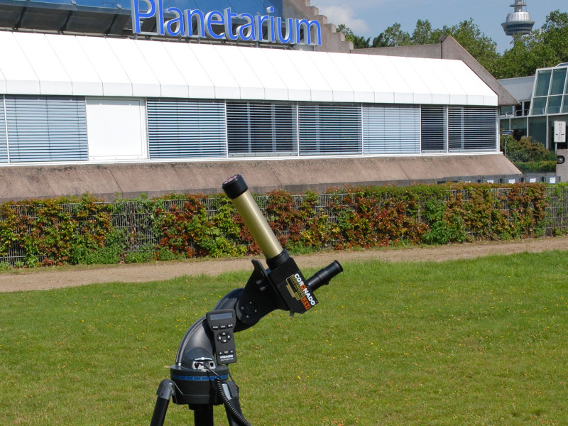 Link zu Informationen über das Mentorentraining für neue AstroScouts auf der Homepage des Planetarium Mannheim – Das Bild zeigt ein Sonnenteleskop, das auf dem Europaplatz hinter dem Planetarium steht. 