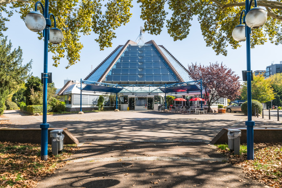 Das Bild zeigt den Eingangsbereich des Planetarium Mannheim bei Tag aus etwas größerer Entfernung bei schönem Wetter.