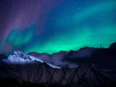 Link zur Beschreibung der aktuellen Ereignisse am Sternhimmel im Januar 2026 – Das Bild zeigt eine Schneebedeckte Landschaft, über sind ist am nächtlichen Himmel Polarlichter zu sehen.