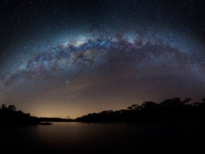 Link zur Beschreibung der aktuellen Ereignisse am Sternhimmel im September 2025 – Das Bild zeigt die Milchstraße über einem nächtlichen See.
