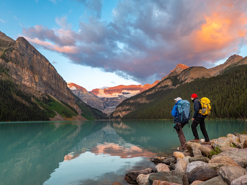 Link zur Beschreibung der Sonderveranstaltung „Kanada - Durch Wildnis und Weite“ - Das Bild zeigt Achill und Aaron Moser, die an einem See in Kanada stehen. Sie schauen auf den See. Im Hintergrund befinden sich Wälder und Berge.