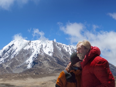 Link zur Beschreibung der Veranstaltung Abenteuer Afrika - Safari zum Himmel. Das Bild zeigt Achill und Aaron Moser vor der Besteigung des Kilimandscharo. Im Hintergrund ist der Kilimandscharo mit schneebedecktem Gipfel zu sehen.