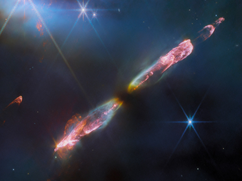 Link zur Beschreibung des Vortrags „Sturm und Drang im All: Was Sterne von sich geben“ am 19.03.2026 - Das Bild zeigt das Herbig-Haro-Objekt 211, zwei entgegengesetzte länglich ausgedehnte leuchtende Gasnebel in der Umgebung eines jungen Sterns.