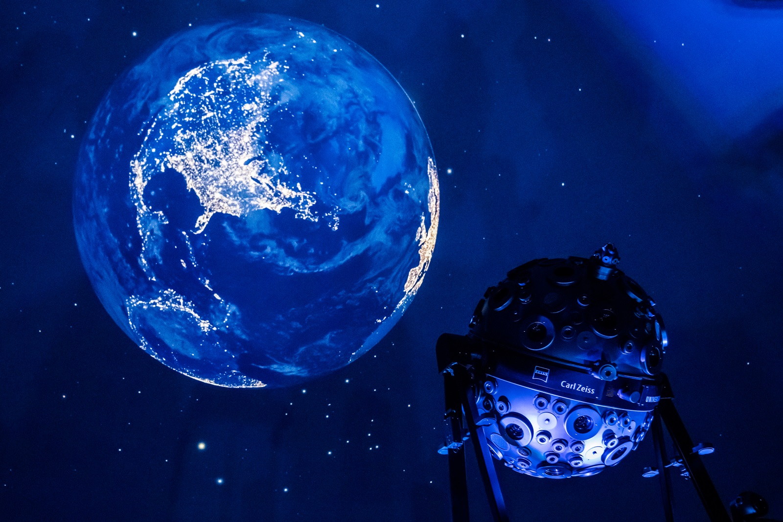 Das Bild zeigt eine Projektion der Erde vor dem Sternhimmel an der Planetariumskuppel sowie den Sternenprojektor Universarium. Das Bild zeigt eine Projektion der Erde vor dem Sternhimmel an der Planetariumskuppel sowie den Sternenprojektor Universarium.
