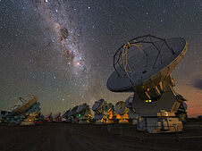 Das Bild zeigt mehrere Teleskope des Observatoriums ALMA der ESO in Chile, die in den Nachthimmel gerichtet sind und die Gestirne im Bereich der Submillimeterwellen beobachten.
