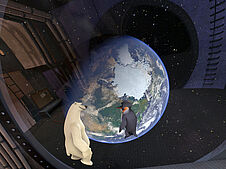 Das Bild zeigt den Eisbären Vladimir und den Pinguin James in ihrem Raumschiff im Weltall. Sie schweben in der Schwerelosigkeit und blicken durch ein großes Fenster auf den Nordpol der Erde (künstlerische Darstellung).