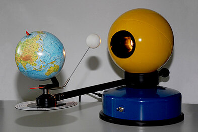 Das Bild zeigt ein Tellurium. Mit diesem Modell kann man die jahreszeitliche Bewegung der Erde um die Sonne und die Bewegung des Mondes um die Erde darstellen.