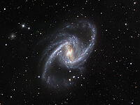 Auf dem Bild ist eine dichte Ansammlung von Sternen zu sehen. Das ist die Galaxie „NGC 1365“. In der Mitte sieht man den gelblichen Galaxienkern. Darum herum sieht man die bläulichen Spiralarme. Wenn man das Bild anklickt, wird es größer dargestellt.